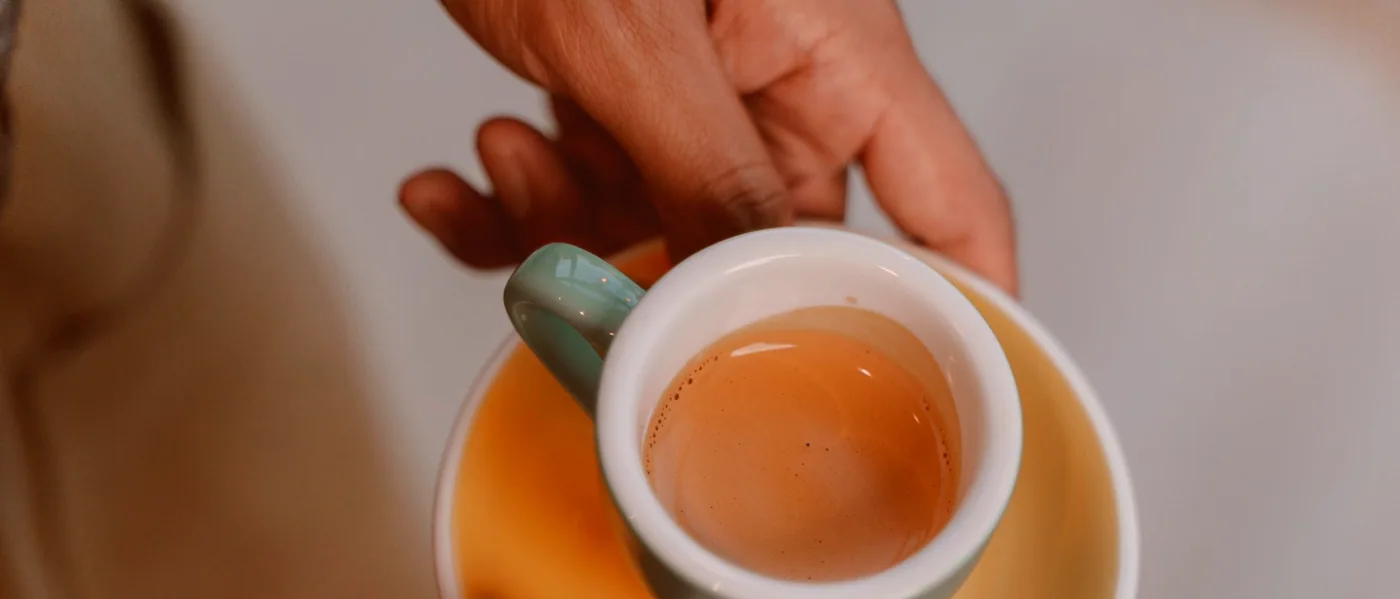 A teapot and glass of lemonade set by the window